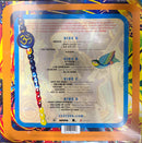 The back cover of a physical music album, likely a vinyl record, featuring a colorful tracklist with four sides. The design is highly vibrant and patterned with a central blue border containing the track information.