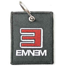 Gray keychain with red and white logo on a white background