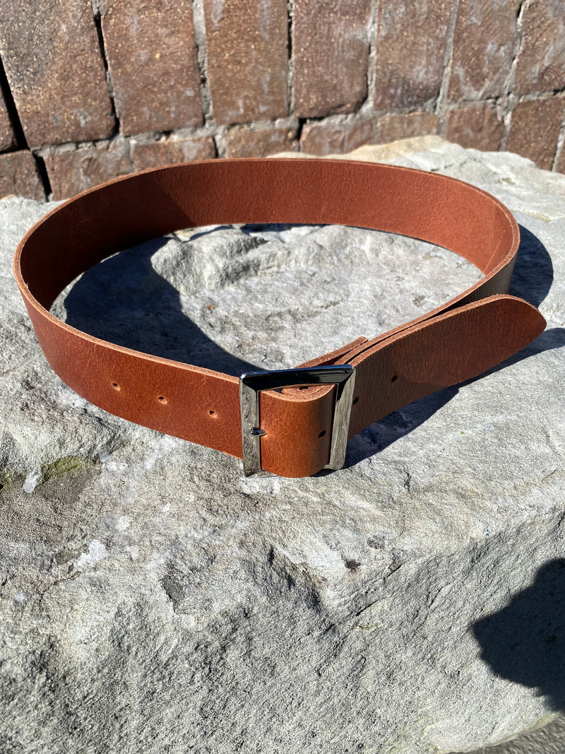 Brown leather belt on a stone surface