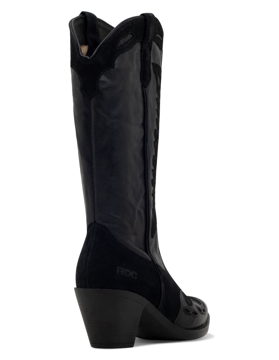 A black suede boot with a pointed toe, decorative suede leather overlays, and a low heel.