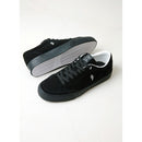 A pair of black suede skate shoes with white details, designed by Dustin Dollin.