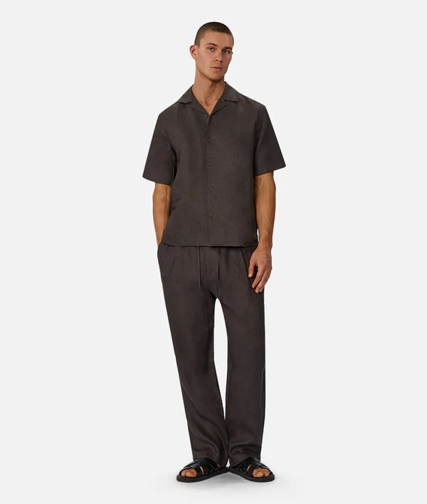 Man wearing a dark brown shirt and pants on a white background