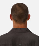 Back view of a person wearing a dark shirt on a white background