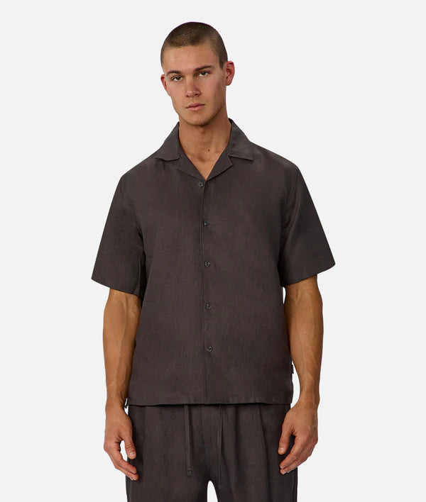 Man wearing a dark brown shirt and pants on a white background