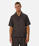 Man wearing a dark brown shirt and pants on a white background