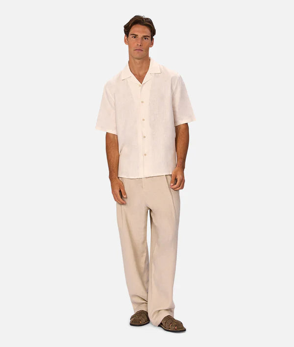 Man wearing a beige shirt and pants on a white background
