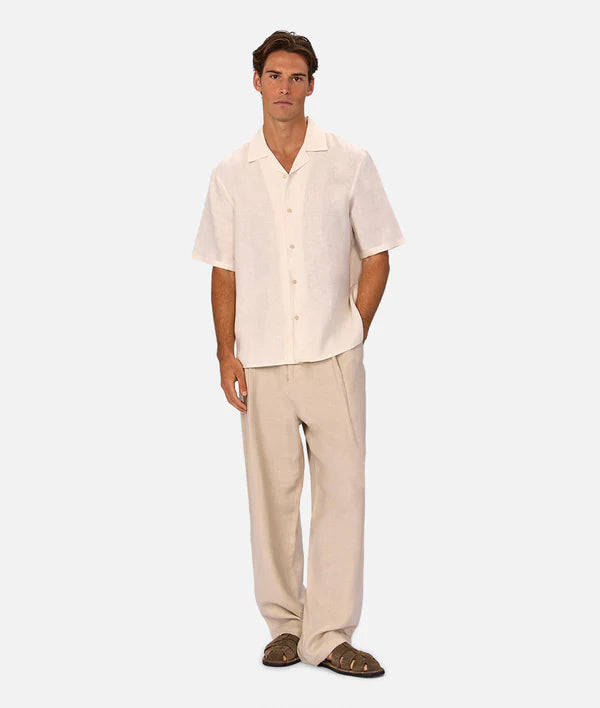 Man wearing a beige shirt and pants on a white background