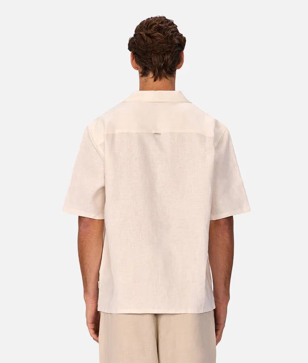 Person wearing a beige shirt and pants on a white background