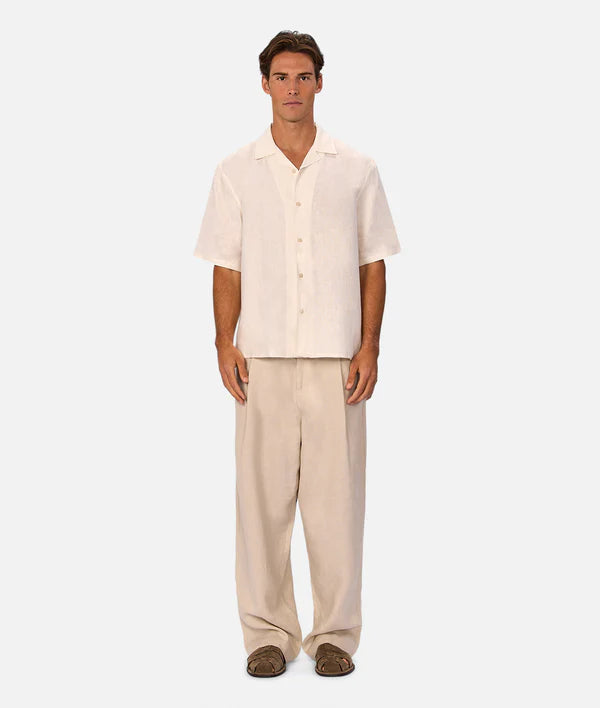 Man wearing a beige shirt and pants on a white background