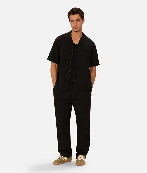 Man wearing a black outfit on a white background