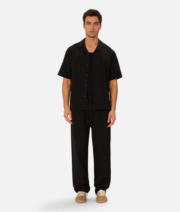 Man wearing a black outfit on a white background