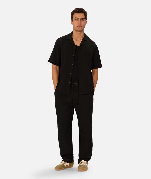 Man wearing a black outfit on a white background