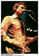Jeff Buckley playing guitar on stage with a microphone in front of him.