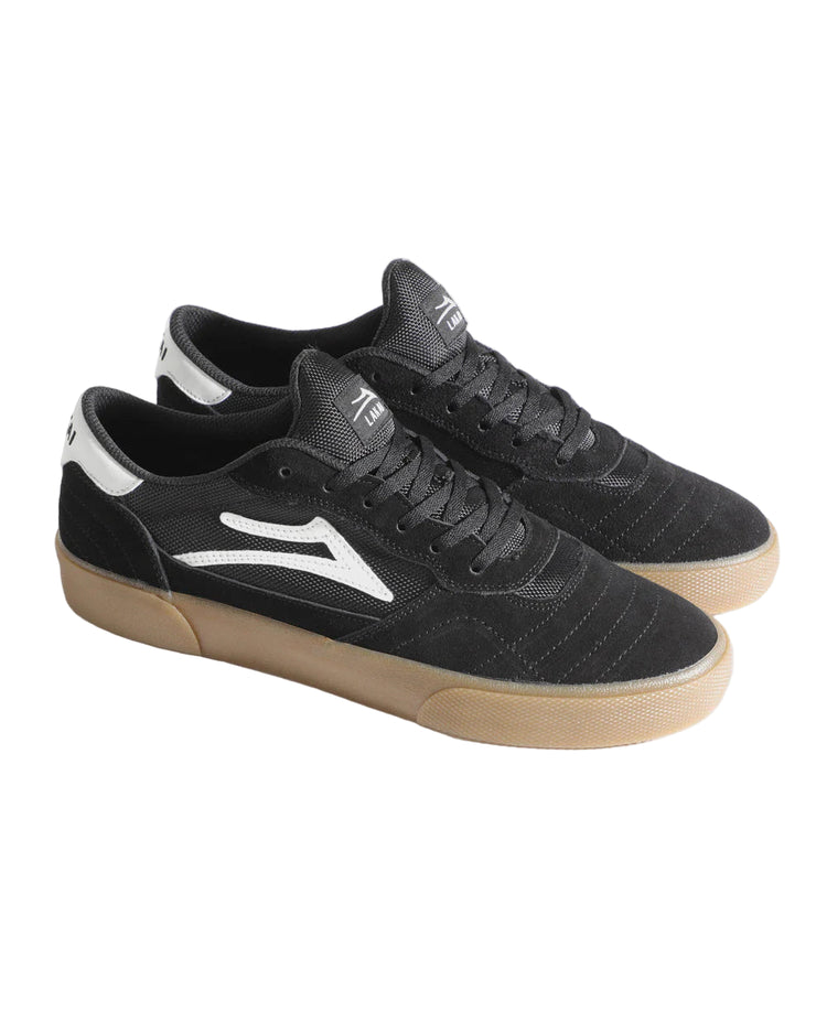Black sneakers with white logo and tan soles on a light gray background