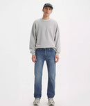 Person wearing a gray sweatshirt and blue jeans on a white background