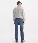 Person wearing blue jeans and a gray sweatshirt on a white background