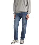 Person wearing blue jeans and a gray sweatshirt on a white background
