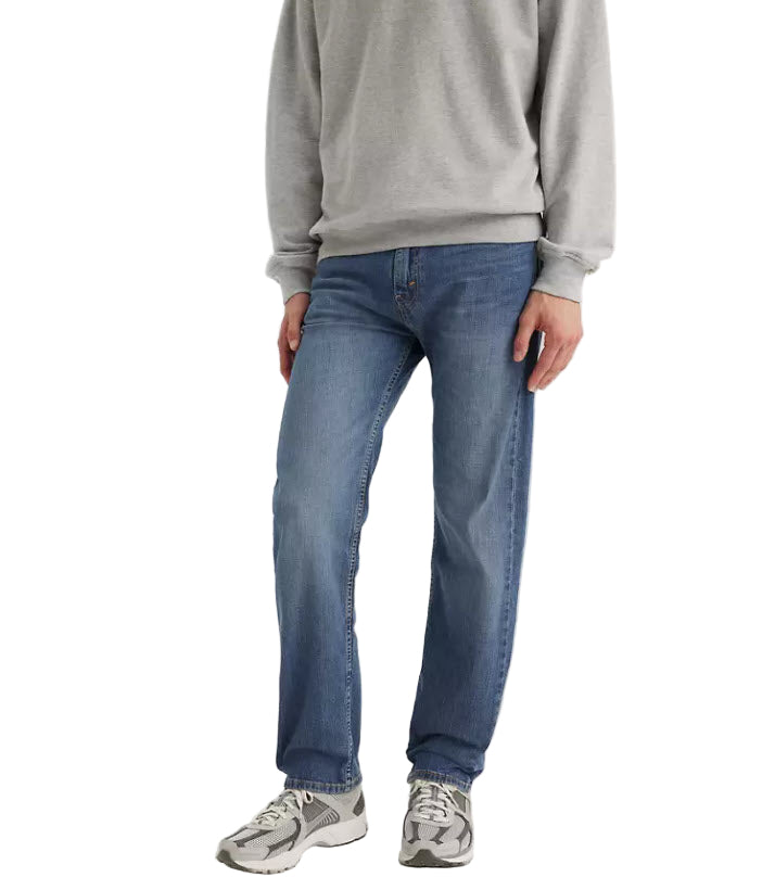 Person wearing blue jeans and a gray sweatshirt on a white background