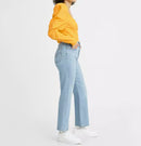 Person wearing a yellow sweater and light blue jeans on a white background