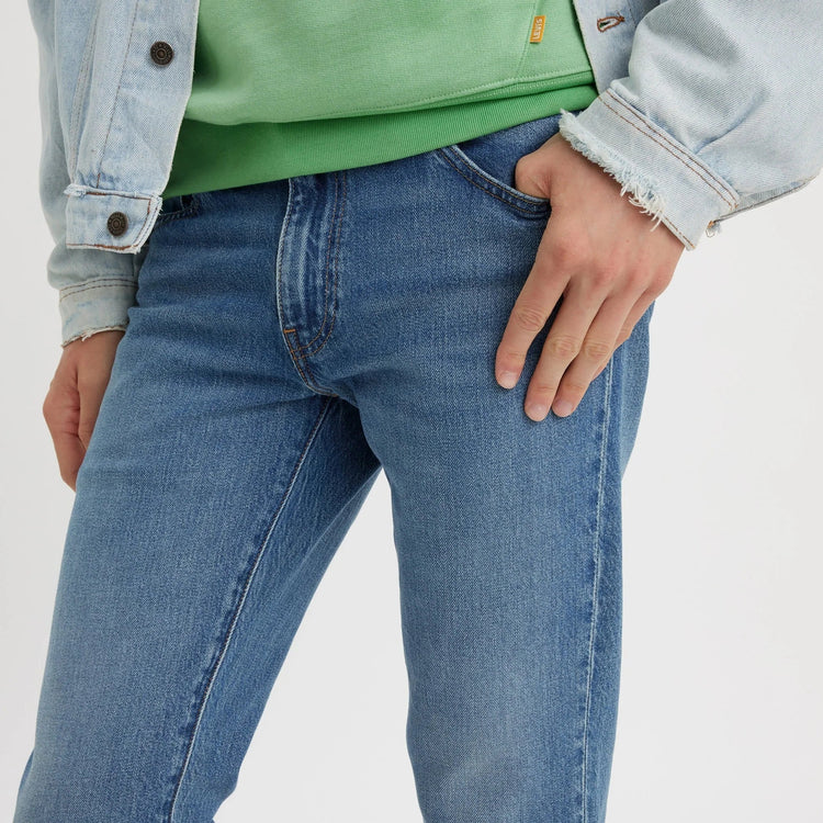 Person wearing blue jeans with a light gray background