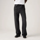 Person wearing black jeans on a plain background