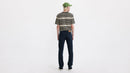Person wearing a striped shirt, dark jeans, and a green cap on a white background