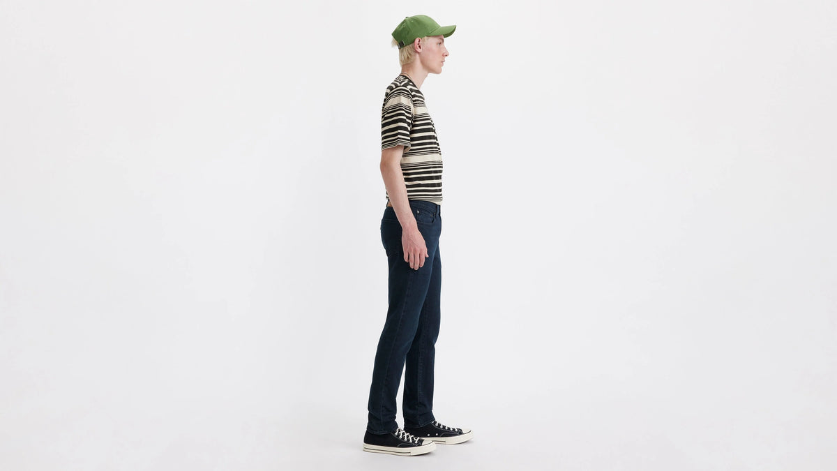 Person wearing a striped shirt and green cap on a white background