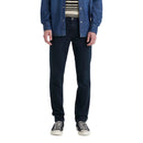 Person wearing a denim jacket, striped shirt, dark jeans, and black sneakers on a white background