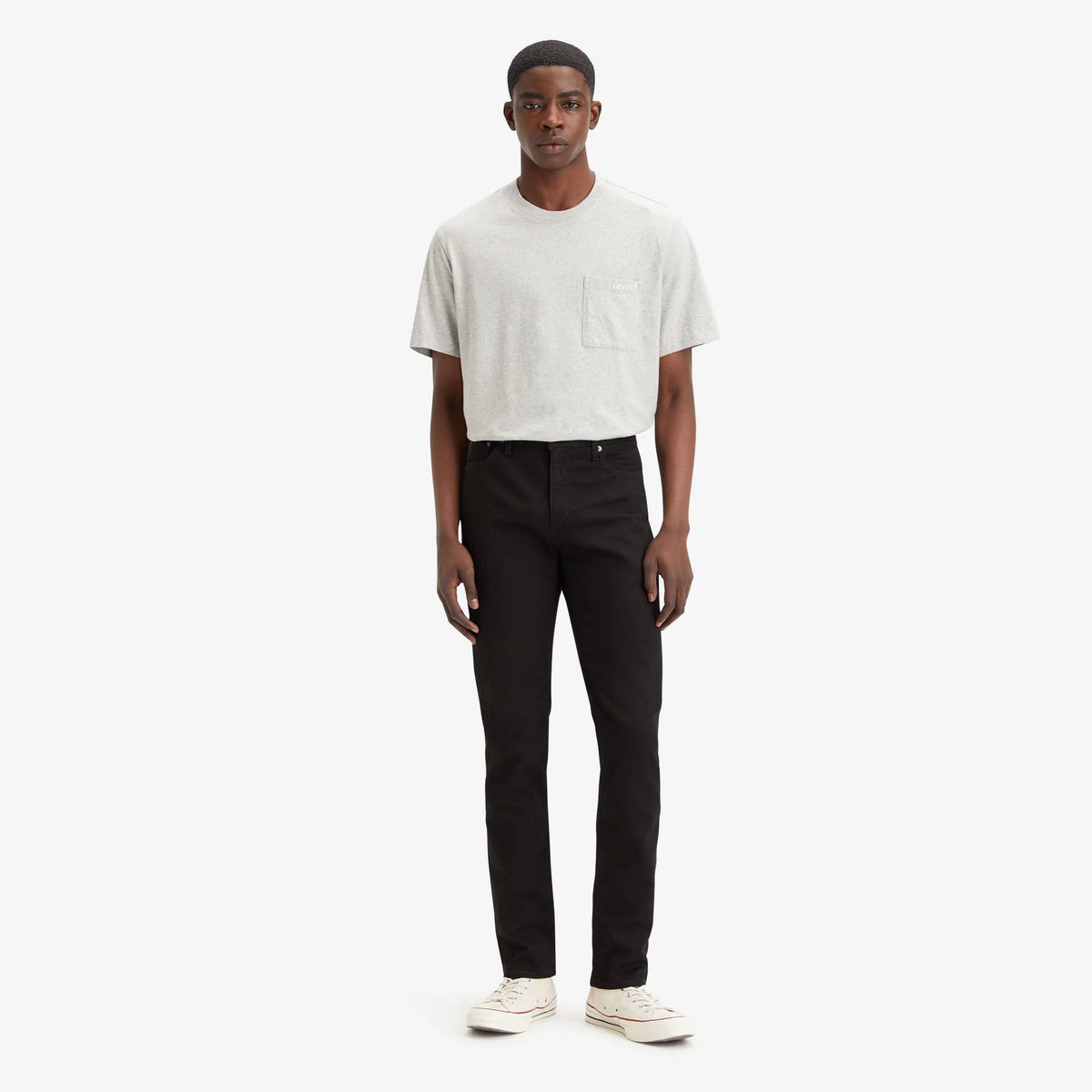 Man wearing a white t-shirt and black pants on a white background