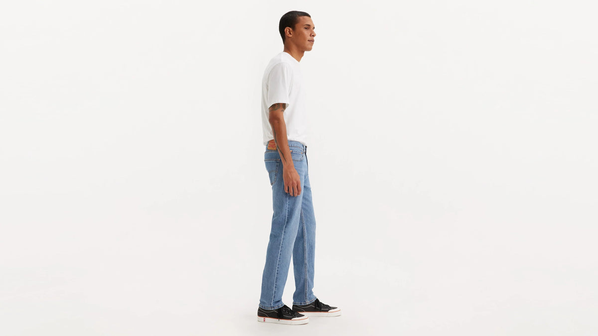 Person wearing blue jeans and a white shirt on a white background