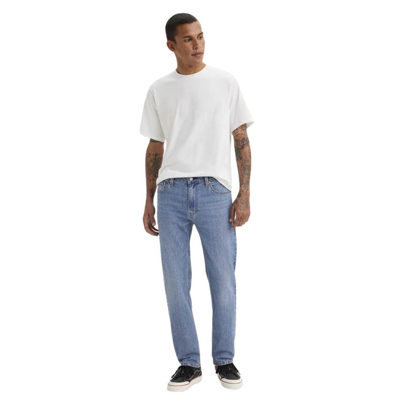 Man wearing a white t-shirt and light blue jeans on a white background