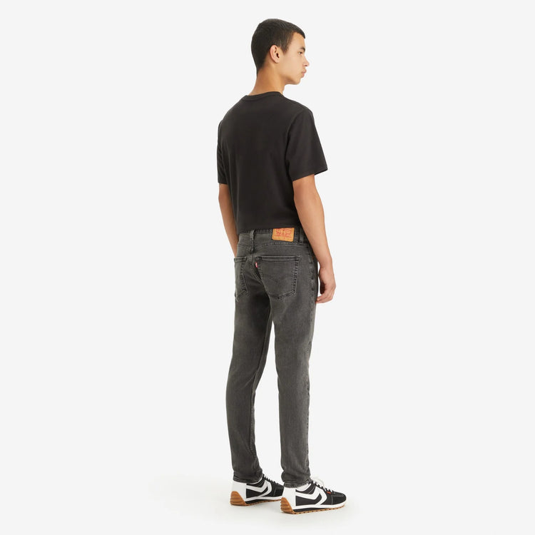 Person wearing gray jeans and a black t-shirt on a white background