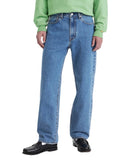 Person wearing blue jeans and a green sweater on a white background