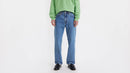 Person wearing a green sweater and blue jeans on a white background