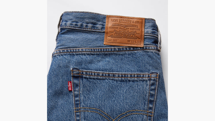 Close-up of blue Levi's jeans with a brown leather label on a white background