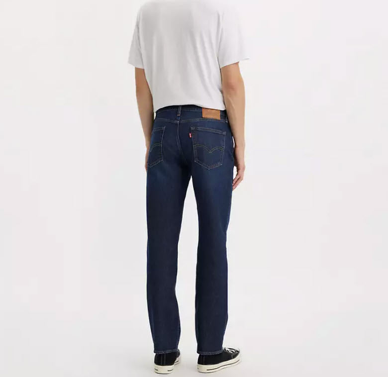 Person wearing dark blue jeans and a white shirt on a white background