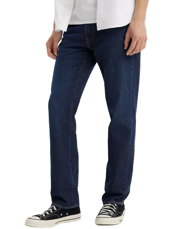Person wearing dark blue jeans and a white shirt on a white background