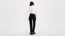 Person wearing a white shirt and black pants on a white background