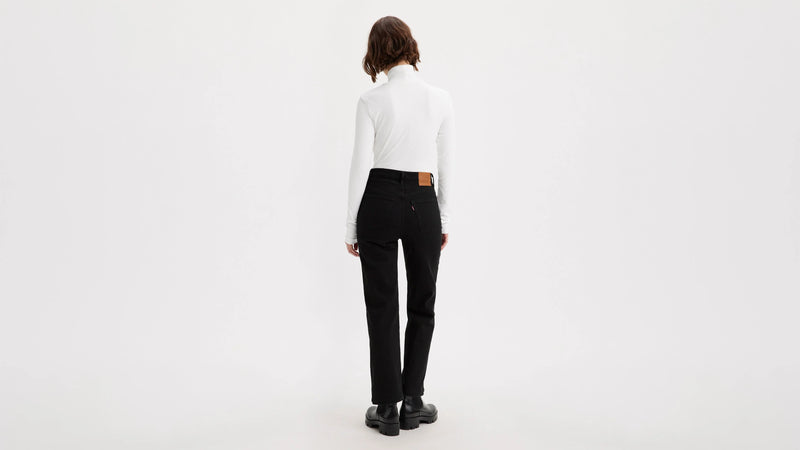 Person wearing a white shirt and black pants on a white background