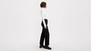 Person wearing a white shirt and black pants on a white background