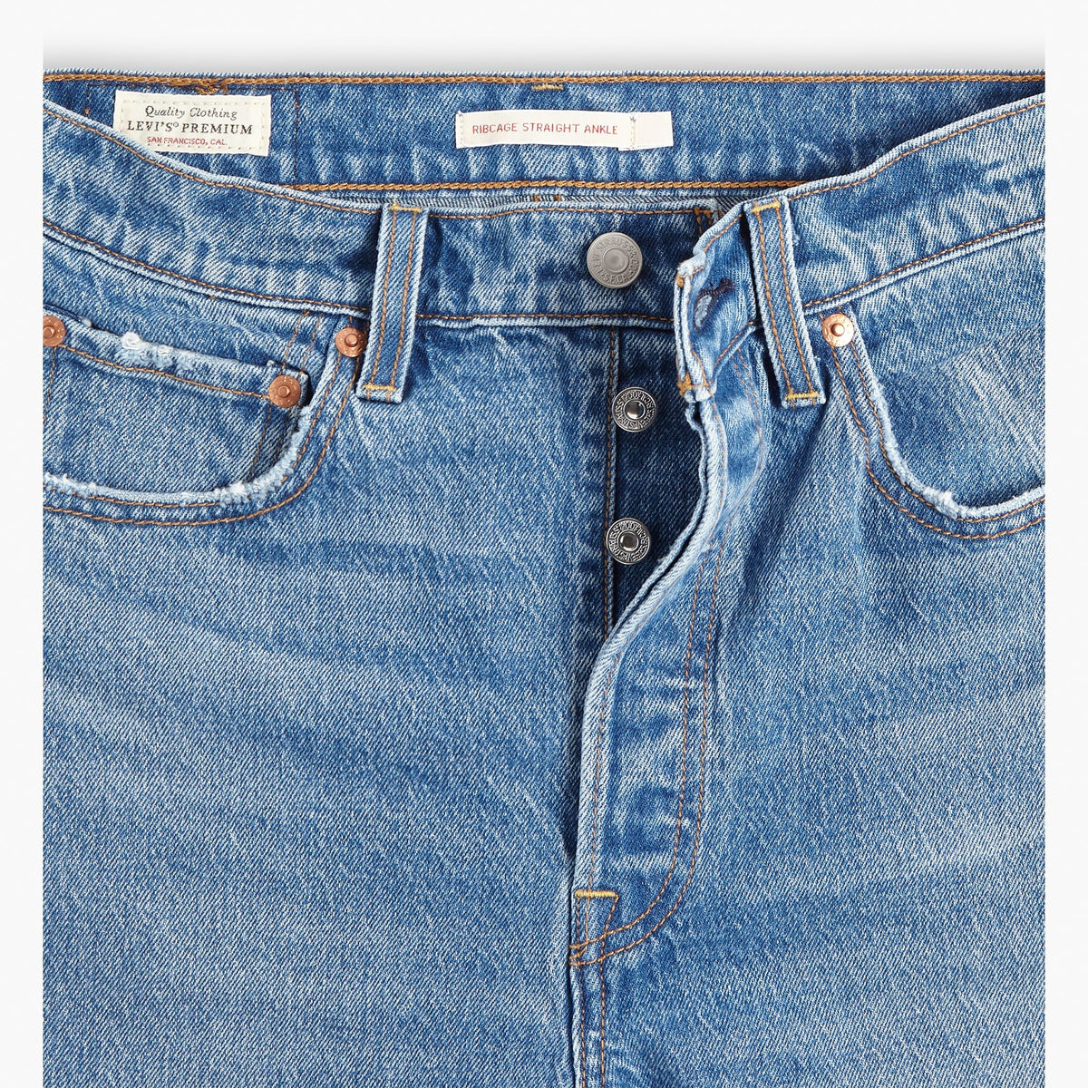 Close-up of blue jeans with Levi's branding on a white background