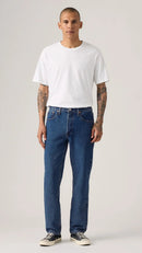 Man wearing Levi's blue jeans and a white t-shirt on a plain background