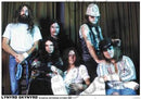 Group photo of Lynyrd Skynyrd members with a curtain background