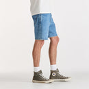Person wearing blue denim shorts and green high-top sneakers on a white background