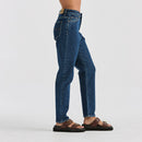 Person wearing blue jeans and brown sandals on a white background