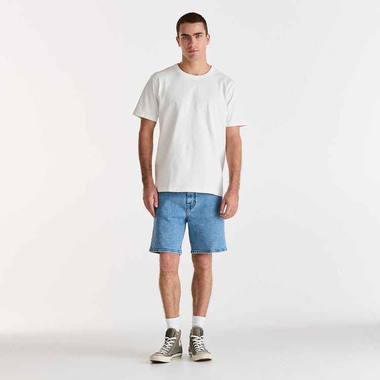 Man wearing a white t-shirt and blue denim shorts on a white background