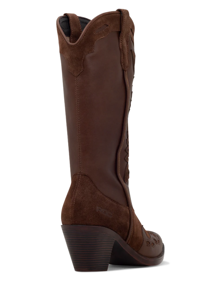 A tan suede boot with a pointed toe, decorative leather overlays, and a chunky heel.