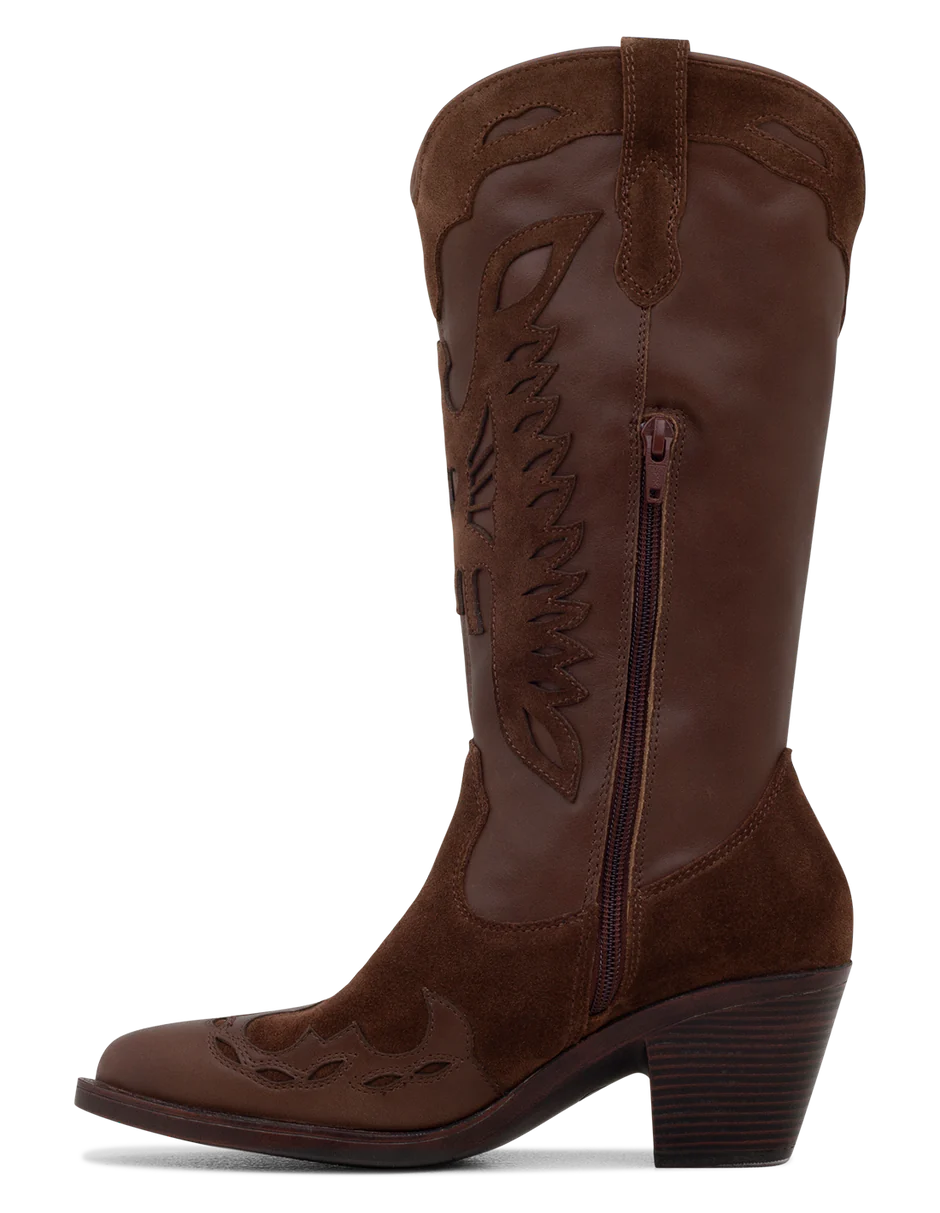 A tan suede boot with a pointed toe, decorative leather overlays, and a chunky heel.