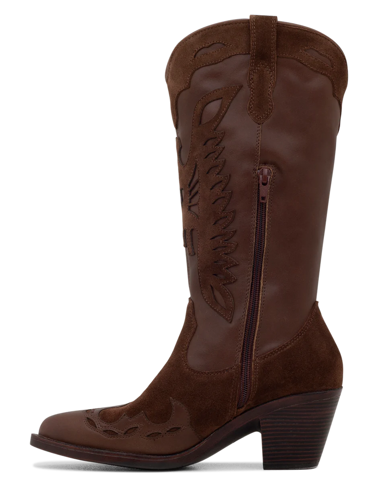 A tan suede boot with a pointed toe, decorative leather overlays, and a chunky heel.