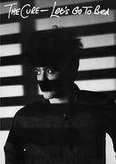 Black and white album cover with a person wearing a mask against striped background, featuring text 'The Cure - Let's Go To Bed'.